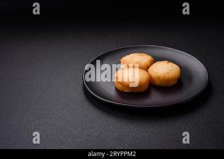 Köstliche frische süße Käsepfannkuchen mit Rosinen und Zimt auf einem Keramikteller Stockfoto