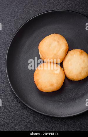 Köstliche frische süße Käsepfannkuchen mit Rosinen und Zimt auf einem Keramikteller Stockfoto