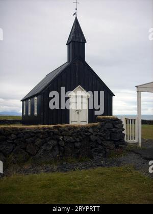 Eine winzige Holzkirche aus dem 19. Jahrhundert in einer malerischen Gegend mit einem Lavafeld in Island. Stockfoto