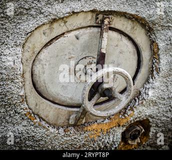 Altes rostiges Lukenventil an einem grauen Tank Stockfoto