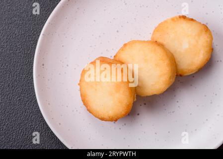 Köstliche frische süße Käsepfannkuchen mit Rosinen und Zimt auf einem Keramikteller Stockfoto