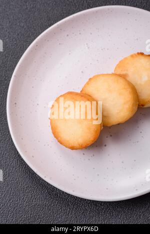 Köstliche frische süße Käsepfannkuchen mit Rosinen und Zimt auf einem Keramikteller Stockfoto