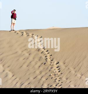 Eine Frau, die auf einer Sanddüne im Death Valley National Park, Kalifornien, steht. Stockfoto