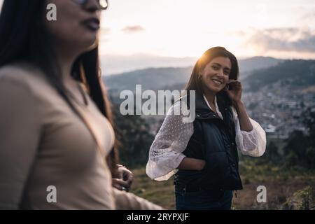 Eine schöne Frau beobachtet fröhlich ihren Freund draußen bei Sonnenuntergang Stockfoto