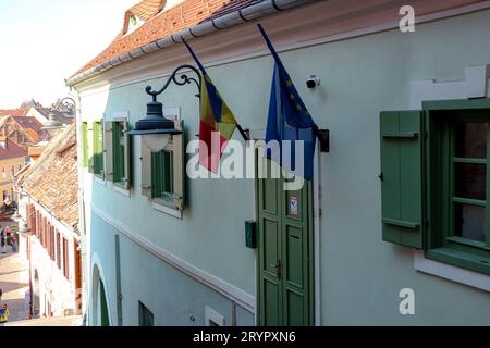 Flagge Rumäniens und Flagge der Europäischen Union, die an einer Wand an einem Gebäude in Sibiu hängt Stockfoto