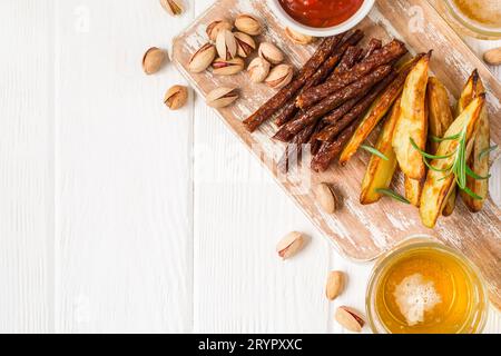 Eine Auswahl an verschiedenen Snacks für Bier wird auf einem Schneidebrett und Bier serviert Stockfoto
