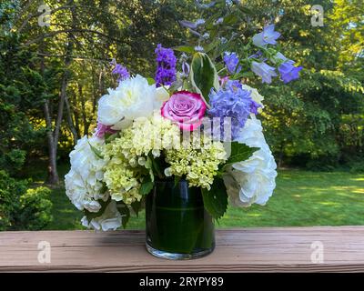 Blumenstrauß in Glasvase im Frühlingsgarten. Stockfoto