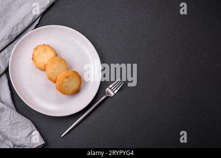 Köstliche frische süße Käsepfannkuchen mit Rosinen und Zimt auf einem Keramikteller Stockfoto