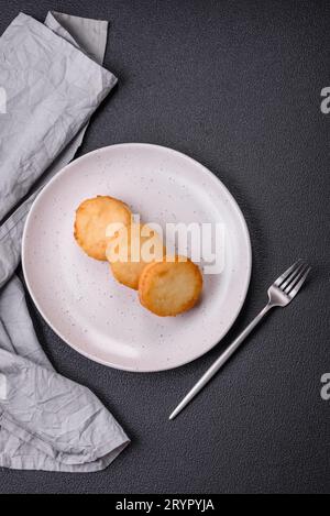 Köstliche frische süße Käsepfannkuchen mit Rosinen und Zimt auf einem Keramikteller Stockfoto