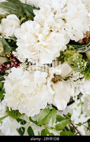 Eine lebhafte und üppige Nahaufnahme einer Sammlung von Blumen und üppigen Blättern in einem Blumenstrauß Stockfoto