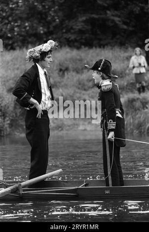 Umzug der Boote, der 4. Juni Gründertag, jetzt Elterntag am Eton College. Jungs in Seekostümen und Blumenhüten, während sie die Schule passieren, stehen auf und grüßen, indem sie ihre Ruder anheben, was manchmal zu ihrem Knattern führt, zur großen Freude der Menge. Eton, Windsor, Berkshire, England Juni 1971. 1970ER JAHRE UK HOMER SYKES Stockfoto