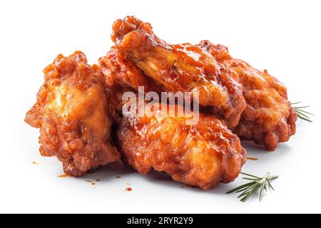 Eine appetitliche Platte mit gebratenen Hähnchenflügeln, serviert mit einer Seite Sauce und einem Zweig Rosmarin zum Garnieren Stockfoto