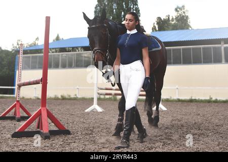 Junge Frau führt ihr Pferd zum Training und zur Vorbereitung Für die Hippodrome-Rennen Stockfoto