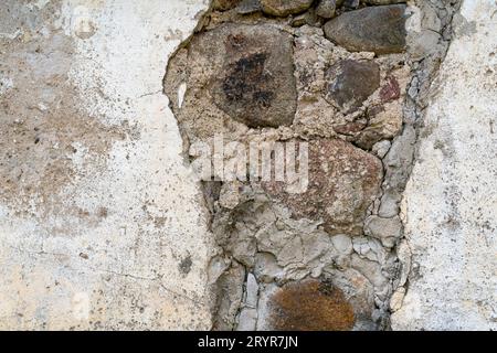 Hintergrund der alten Steinmauer mit abgefallenem Gips Stockfoto