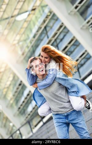Glücklich junge kaukasischen Paar mit Spaß mit Huckepack im Freien Stockfoto