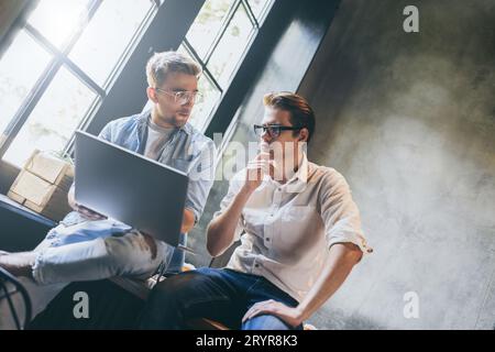 Zwei Geschäftskollegen sitzen an einem Tisch und treffen sich. Stockfoto