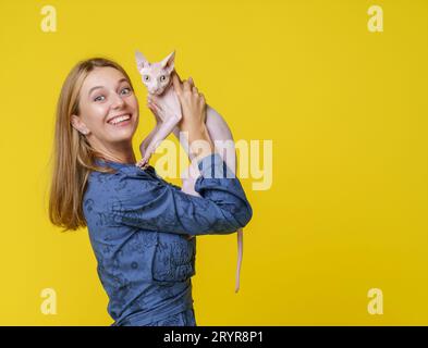 Die Frau teilt den Moment der Herzerwärmung mit der geliebten Katze und küsst sie liebevoll und hält sie in den Händen. Eine tiefe Bindung und Liebe zwischen Haustierbesitzer und Katzenbegleiter, die eine freudige und geschätzte Verbindung widerspiegelt. Hochwertige Fotos Stockfoto