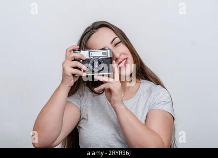 Attraktive Frau, die Fotos macht. Сamera in den Händen der Frau. Stockfoto