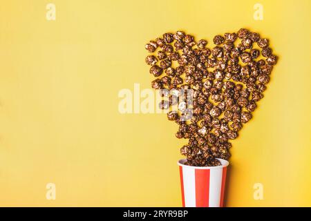 Süßes Schokoladenpopcorn in weiß-roter Tasse mit Papierstreifen Stockfoto