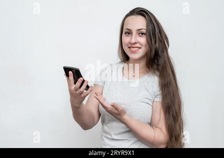 Eine Frau mit langen dunklen Haaren hält den Rechner in der Hand. Unternehmen, Geld, Gewinne. Stockfoto