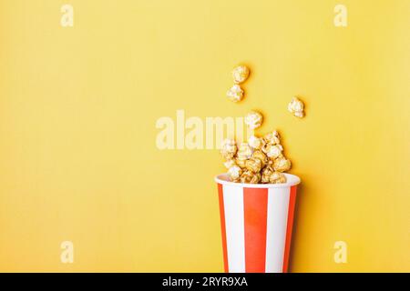 Süßes Karamell-Popcorn in papiergestreifter weißer roter Tasse Stockfoto