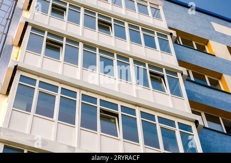 Modernes Haus mit gelben und blauen Wänden und leeren Fenstern Stockfoto