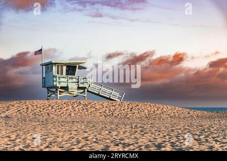 Rettungsschwimmerturm am Strand in Santa Monica, Kalifornien, während eines wunderschönen Sonnenuntergangs mit dramatischen Wolken. Stockfoto