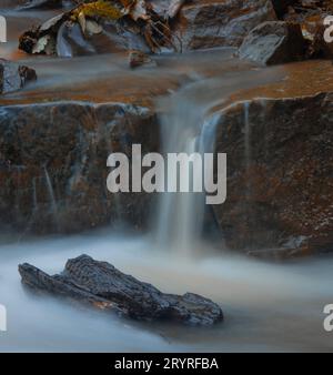 Ein malerischer Blick auf einen Wasserfall, der die Felsen hinunterragt Stockfoto