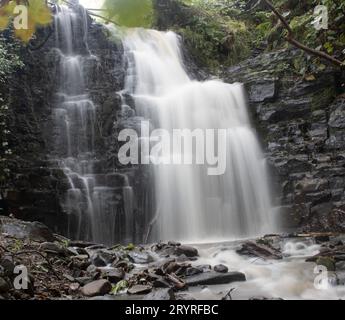 Ein malerischer Blick auf einen Wasserfall, der die Felsen hinunterragt Stockfoto