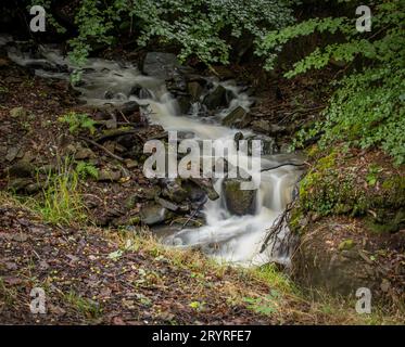 Ein malerischer Blick auf einen Wasserfall, der in Wales die Felsen hinunterfällt Stockfoto