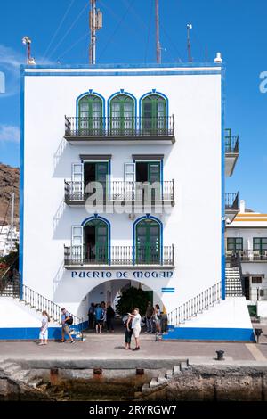 Ein Bild des Yachthafens in Puerto de Mogan Gran Canaria Spanien. Touristen werden gezeigt, wie sie ein Selfie vor einem Gebäude mit dem Namen der Stadt an der Wand machen Stockfoto