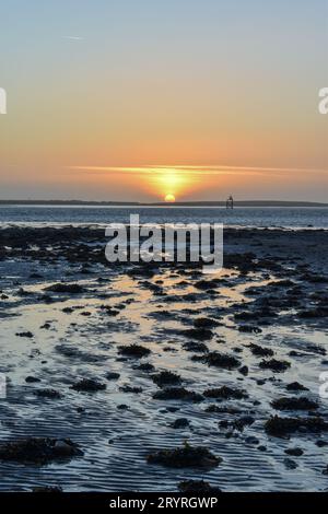 Ein Blick auf den Sonnenuntergang von Roa Island bei Ebbe mit Walney Island in der Ferne. Stockfoto