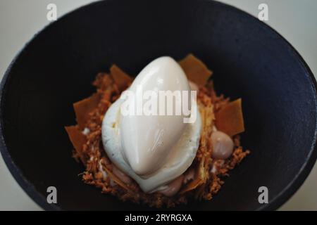 Crème Caramel vs Mille-Feuille, dekonstruiertes Dessert in einer schwarzen Dessertschüssel - feine Küche im Bennelong Restaurant, Sydney Opera House, Australien Stockfoto