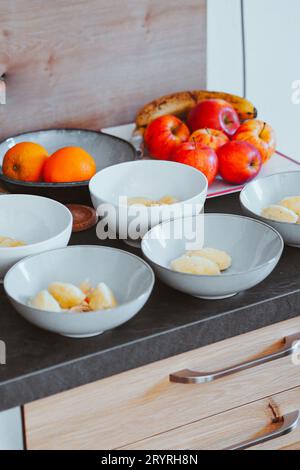 Ein Bild aus der Nähe eines Holztisches mit einer Vielzahl von frischen Früchten, darunter Bananen, Äpfel, Orangen und Trauben Stockfoto