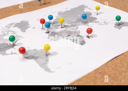 Nahaufnahme der Kugelnadeln auf der Weltkarte auf Corkboard. Konzept für Reiseziele Stockfoto