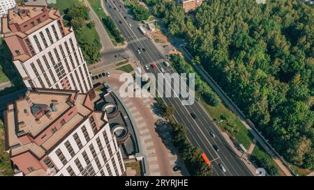 Drohnenblick auf die Stadtstraße mit Autos und Apartmentkomplex Stockfoto