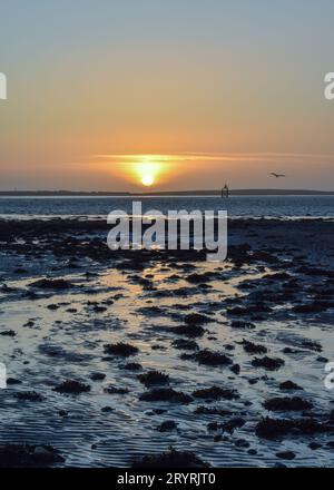 Ein Blick auf den Sonnenuntergang von Roa Island bei Ebbe mit Walney Island in der Ferne. Stockfoto