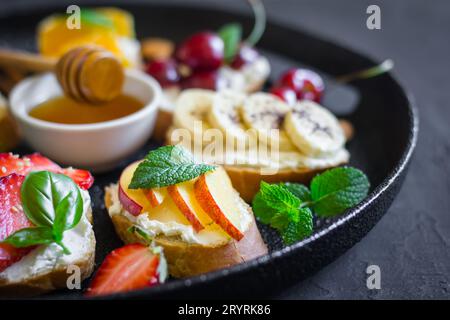 Gericht mit Sommerfrüchten, Beeren, Nüssen, Honig-Sandwiches. Selektiv Stockfoto