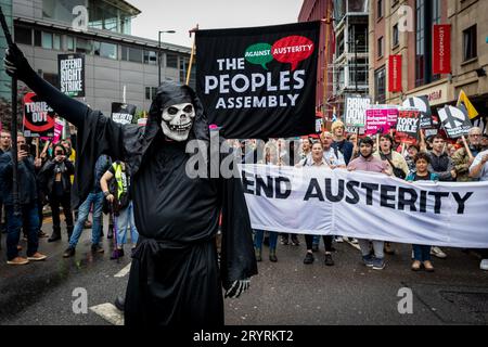 Manchester, Großbritannien. Oktober 2023. Ein als Skelett verkleideter Mann führt den marsch an. Während der Konservativen Partei-Konferenz marschierten die Menschen durch die Stadt, um eine nationale Demonstration durchzuführen. Die Forderungen, die von der Volksversammlung organisiert und von Gewerkschaften unterstützt werden, umfassen die Beendigung der Lebenshaltungskrise und die Verteidigung des NHS. (Foto: Andy Barton/SOPA Images/SIPA USA) Credit: SIPA USA/Alamy Live News Stockfoto