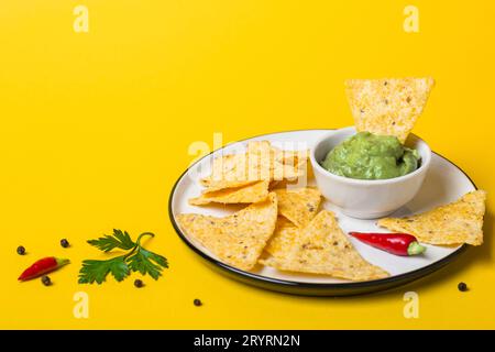 Mexikanisches Essen Guacamole Dip mit Maischips auf gelbem Hintergrund Stockfoto