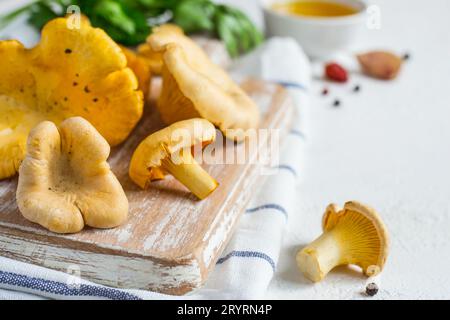 Rohe Pfifferlinge auf einem Schneidebrett Nahaufnahme auf weißem Hintergrund Stockfoto