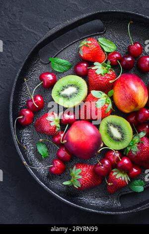 Schwarzes Gericht mit verschiedenen Sommerbeeren und Früchten. Draufsicht Stockfoto