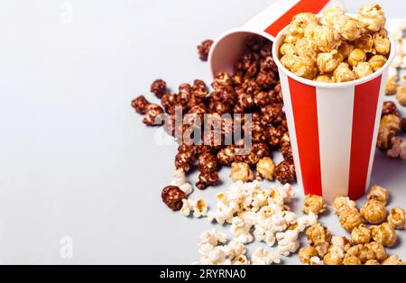 Popcorn-Set in weiß-roter Tasse mit Papierstreifen. Süßes und salziges Popcorn Stockfoto