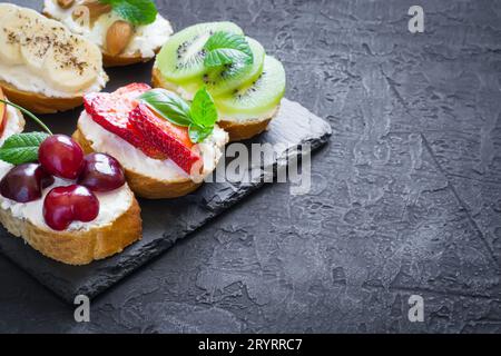 Verschiedene süße Snacks im Sommer. Bruschetta oder Sandwiches mit Früchten Stockfoto