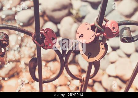 Satz roter herzförmiger Schlösser an Metallstangen. Hochzeitstradition Stockfoto