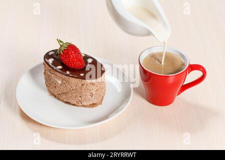 Schokoladenkuchen auf den weißen Teller mit einer Tasse Kaffee Stockfoto