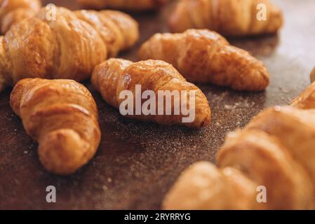 Eine Nahaufnahme einer Auswahl frisch gebackener, buttriger Croissants auf einem Holztisch Stockfoto