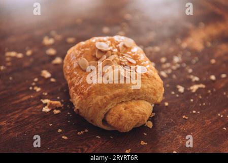 Eine Nahaufnahme eines frisch gebackenen Mandelteigs auf einem Holztisch mit Mehl Stockfoto