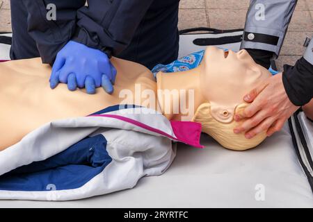 Hände eines Polizisten an einer Schaufensterpuppe während einer Reanimationsübung. HLW-erste-Hilfe-Schulungskonzept.Notfallversorgung. Stockfoto