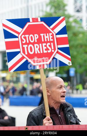 Manchester, Großbritannien - Montag, 2. Oktober 2023 – Ein Demonstrant vor der Konservativen Partei-Konferenz mit einem Schild „Stop the Tories“ - Foto Steven May / Alamy Live News Stockfoto